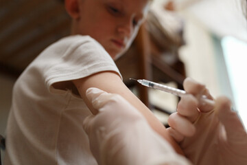 Pediatrician makes vaccination to small boy.