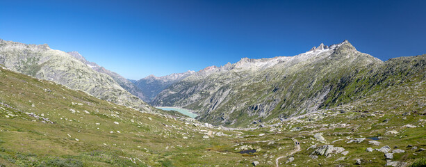 Sunny morning panorama on the top of Grimselpass. Colorful summer in Swiss Alps, canton of Bern in Switzerland, Europe.