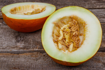 Halves of sweet melon on rustic wooden background