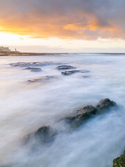 Water flowing between rocks on the beach.