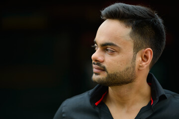 Obraz premium Young handsome bearded Indian businessman in the city