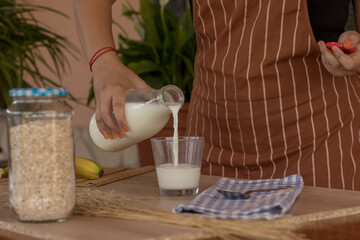 Mujer preparando un vaso de leche para desayunar 