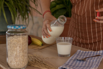 Mujer preparando un vaso de leche para desayunar 
