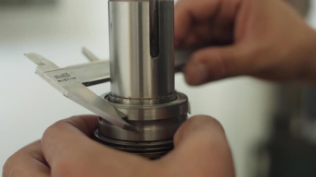 hands working with vernier caliper stainless steel measuring slow motion