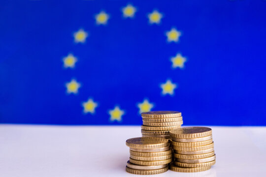 Coins with the Europe blue and yellow flag at the background, economy of europe