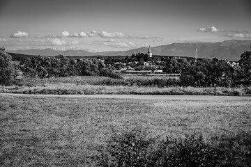 Beautiful countryside landscape of Cincu village, Brasov County, Transylvania region, Romania. Traditional transylvanian saxon village with fortified church in black & white