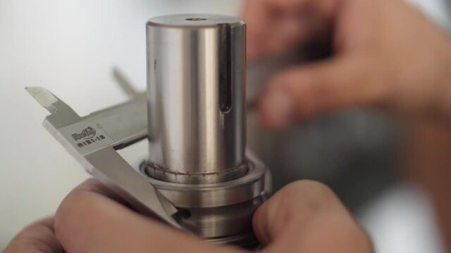 hands working with vernier caliper stainless steel measuring slow motion