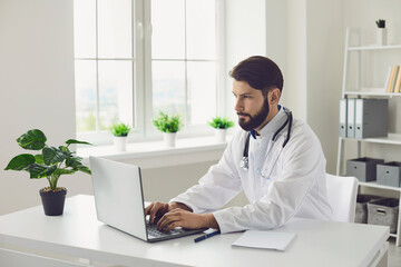 Young male doctor giving online consultation to his client online at clinic. Therapist talking to patient on web