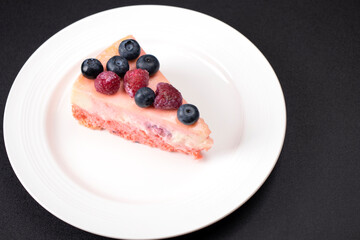 Cheesecake with berries on a white plate. Concept food photography. Sweets and berries. Copy space.