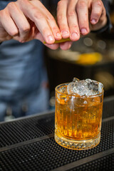 Barman mentre prepara un cocktail poggiato sul bancone di un bar