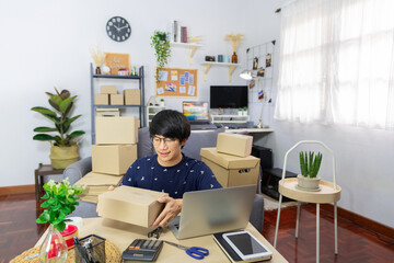 start up small business asian man young entrepreneur preparing parcels packing cardboard box for delivery process for send order to customer at home office, Online marketing.
