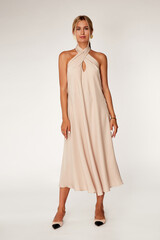 Beautiful woman fashion model makeup blond hair perfect body shape tanned skin wear clothes summer collection organic midi beige silk dress stylish sandals shoes, accessory romantic date walk.