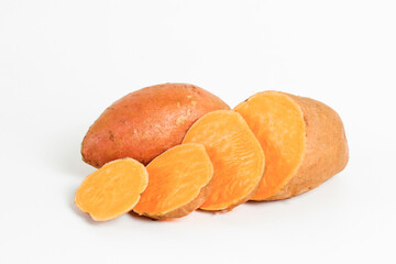 Farm raised organic sweet potato tubers laid in composition on textured background. The edible tuberous root vegetable on table counter. Clean eating concept. Background, close up, flat lay, top view.