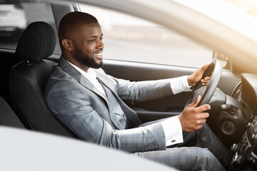 Cheerful african american businessman driving to work