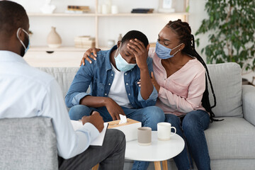 Loving Black Wife Comforting Husband With Coronavirus Panic Attacks At Psychiatrist Office