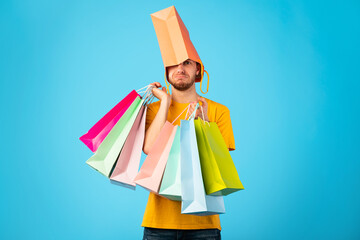 Funny man wearing shopping bags at studio