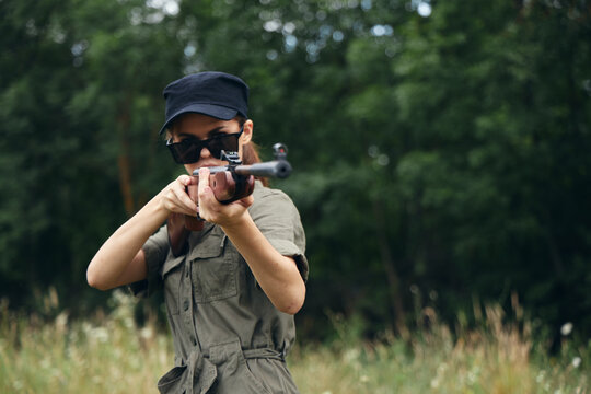 Military woman hold a weapon in your hands sunglasses aiming fresh air 