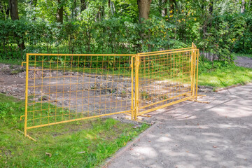 Yellow metal grate warns visitors of the city park about excavation work