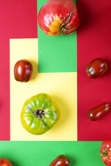 Various tomatoes on the multicolored geometric background. Top view