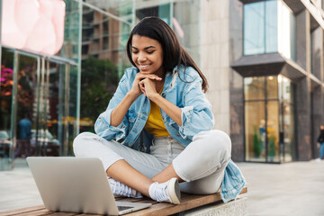Happy young african girl using laptop