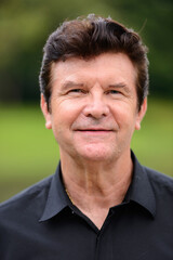 Obraz premium Portrait of happy mature handsome businessman relaxing at the park