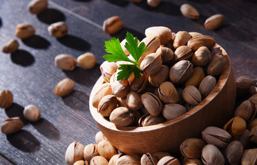Composition with bowl of pistachio on wooden table. Delicacies