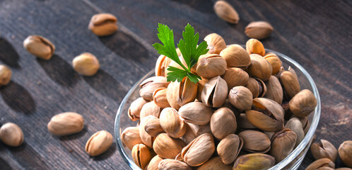 Composition with bowl of pistachio on wooden table. Delicacies