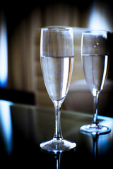 Two glasses of water on a glass table