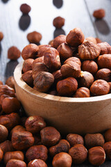 Bowl with hazelnuts on wooden table.