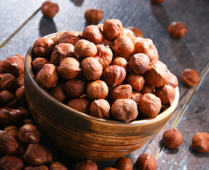 Bowl with hazelnuts on wooden table.