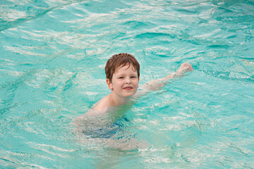 Fototapeta na wymiar Happy preschool boy playing in the swimming pool