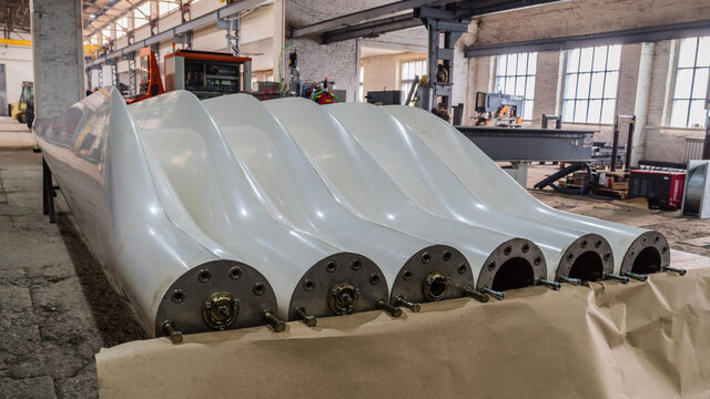 Two sets of freshly made blades for wind turbines in a factory floor. The picture was taken in Russia, in the Orenburg region, in the production room of an industrial enterprise