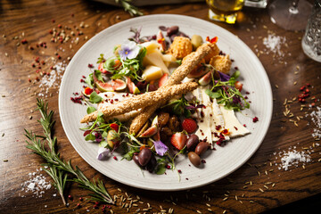 Cheese platter for two: Goat cheese cream, gorgonzola, camembert, grissini and fig jam. Delicious healthy Italian traditional food closeup served for lunch in modern gourmet cuisine restaurant