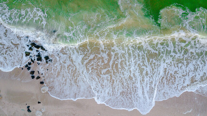 Aerial panoramic drone view of beautiful ocean waves and sand beach