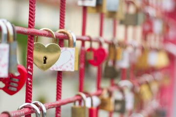 Love locks on the bridge with heart shaped gold lock in the front.
