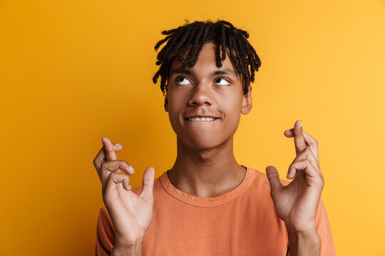 Smiling african manstanding against yellow background