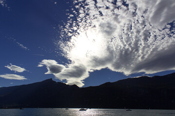 scenic white color cloudscape with  mountain silhouette on sunset light on  lake water reflection