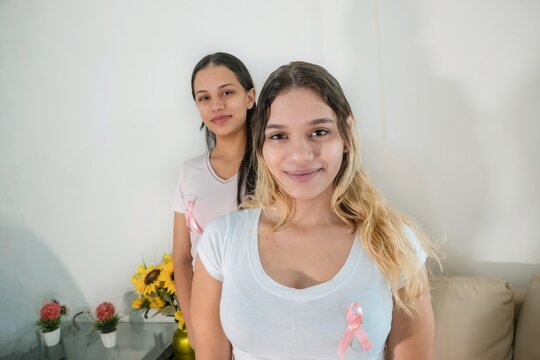 Women laughing with pink ribbon because of breast cancer - Powered by Adobe