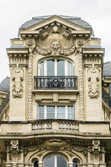 Old French house with traditional balconies and windows. Paris, France.