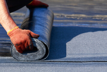 Worker puts roofing material