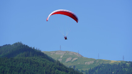 a paraglider on the blue sky