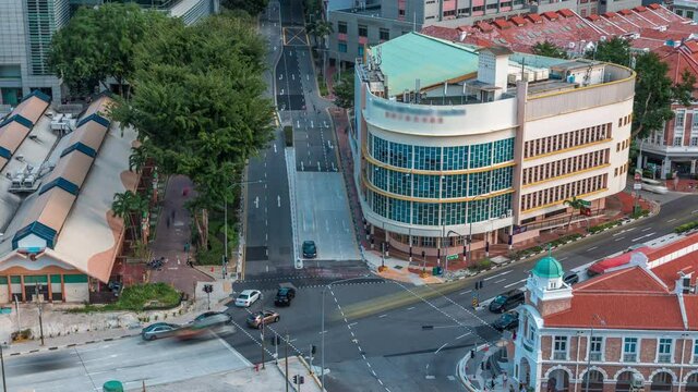 Aerial view of intersection and art deco shophouses with red roofs along Neil road in Chinatown area timelapse. Traffic on the street with crossroad and crossing