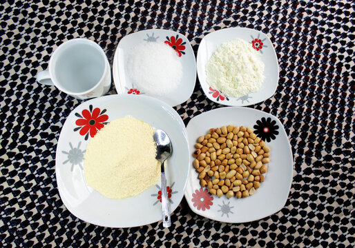 Served on a checkered African table cloth is a meal of Garri, peanuts or groundnuts, milk, sugar and some water. This food items can be combined to create a tasty local cereal popular in Nigeria