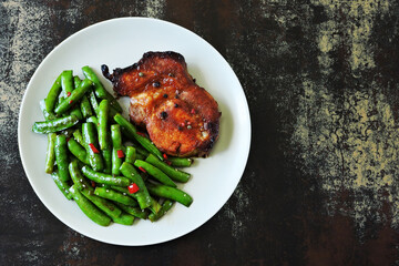 Plate with pork steak and green pea pods. Healthy eating. The keto diet.