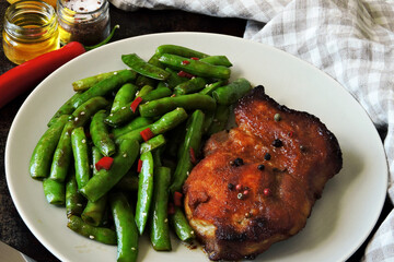 Plate with pork steak and green pea pods. Healthy eating. The keto diet.