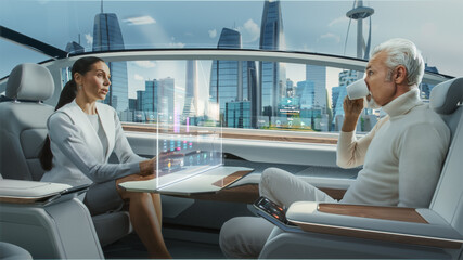 Casual Business Meeting Between Senior Male and Female inside a Futuristic Driverless Autonomous Car with Augmented Reality Presentation Interface. Self-Driving Van Driving on Downtown City Streets.