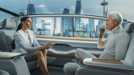 Beautiful Female and Senior Man are Having a Conversation in a Driverless Autonomous Vehicle. Futuristic Self-Driving Van is Moving on a Public Highway in a Modern City with Glass Skyscrapers.