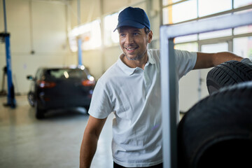 Fototapeta na wymiar Happy car mechanic working in auto repairs shop.