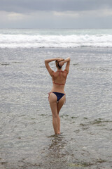 Fototapeta na wymiar Portrait of a brunette caucasian woman in blue bikini on the beach.