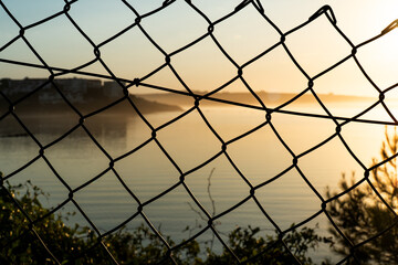 View of the river to the sea through a fence